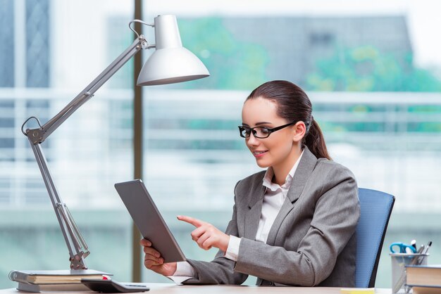 Onderneemster die met tabletcomputer werken in bedrijfsconcept