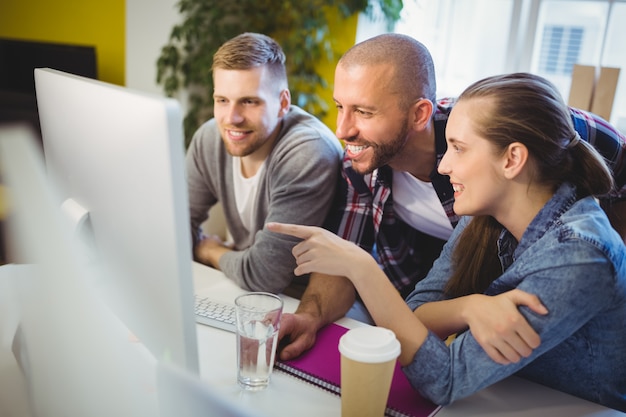 Onderneemster die op computer richt terwijl het bespreken met collega's