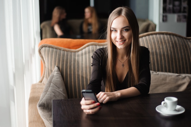 Onderneemster die op telefoon in een koffiewinkel spreekt.