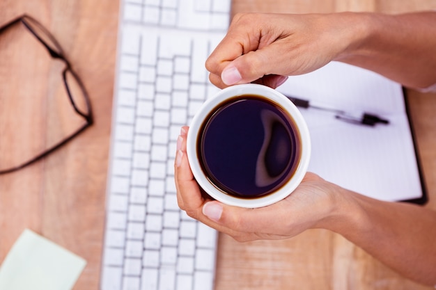 Onderneemster die zwarte koffiekop houdt