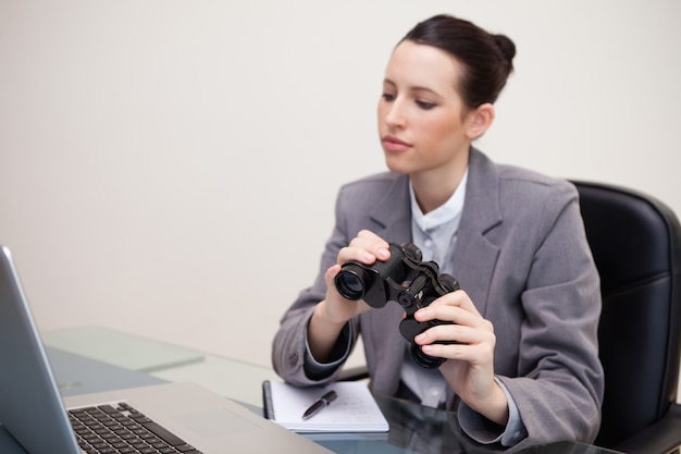 Onderneemster met verrekijkers op haar bureau