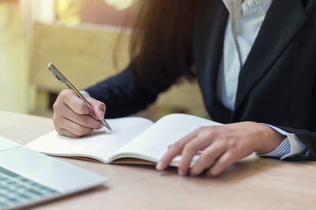 Onderneemsterhand het schrijven controlelijst op notitieboekje, planningsconcept.