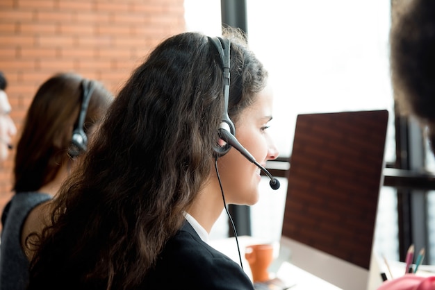 Onderneemsters die microfoonhoofdtelefoon dragen die in call centre werken