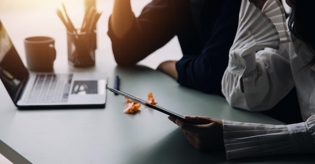 Ondernemer Aziatische zakenman en zakenvrouw bespreken nieuw zakelijk project in tablet in moderne Meeting In Modern Office Aziatisch zakelijk casual concept