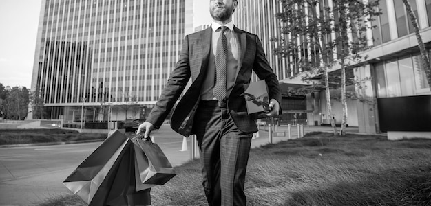 Ondernemer draagt verjaardagscadeau man houdt boodschappentassen heren dag bijgesneden zakenman