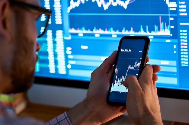 Foto ondernemer handelaar investeerder analist met behulp van mobiele telefoon app analytics voor cryptocurrency financiële aandelenmarkt analyseer grafiek handelsgegevens index investering groei grafiek op smartphone scherm