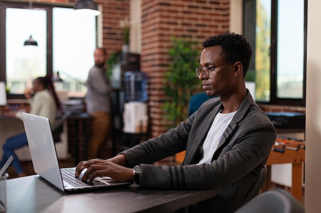 Ondernemer man brainstormen ideeën voor marketingproject tijdens het analyseren van de bedrijfsomzet met behulp van laptopcomputer. zakenman werken in startup office planning management samenwerking