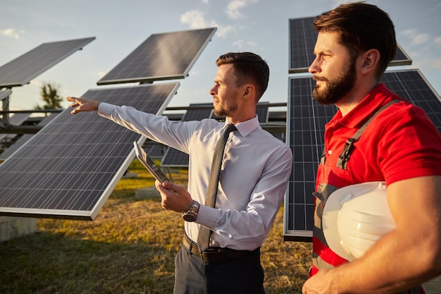 Ondernemer met tablet die zonne-energieproject uitlegt aan aannemer