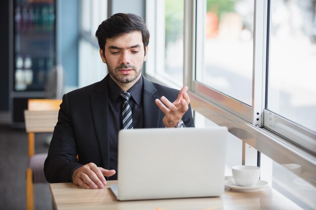 Ondernemer online conferentie met behulp van computer laptop in café teleconferentie werken nieuwe normale