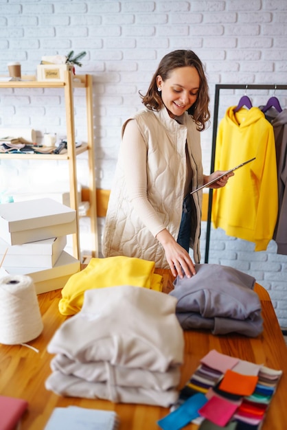Ondernemer verkoper van kleine bedrijven die tablet gebruikt om bestellingen van e-commerce kledingwinkels te controleren