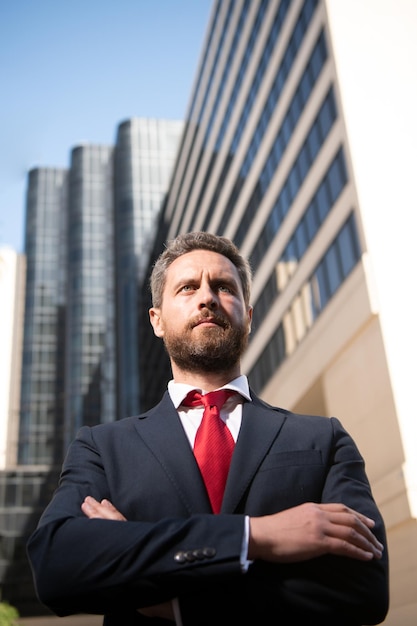 Ondernemer zakelijk portret Zakenman staat trots met gekruiste armen buiten