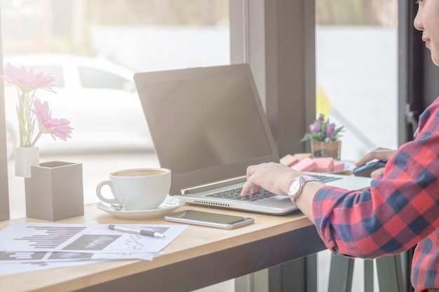 Foto ondernemers gebruiken een smartphone en een laptop in een coffeeshop