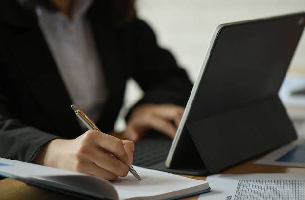 Ondernemers gebruiken laptop en maken aantekeningen van werk op het bureau op kantoor.