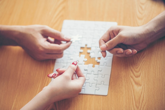 Ondernemers Hand oplossen Puzzel op houten bureau