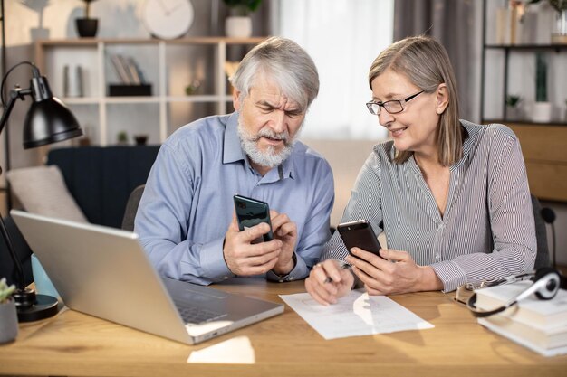 Ondernemers met mobiele telefoons kijken elkaar thuis aan