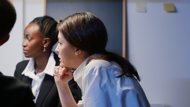 Ondernemersvrouw die financiële grafieken bespreekt die presentatiemonitor gebruiken