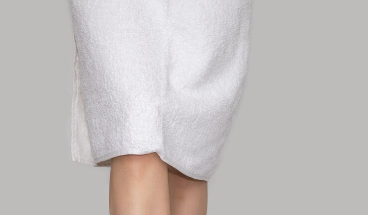 onderste deel van de benen van de vrouw sexy vrouw met witte handdoek op lichaam als jurk na bad lichaamsverzorging