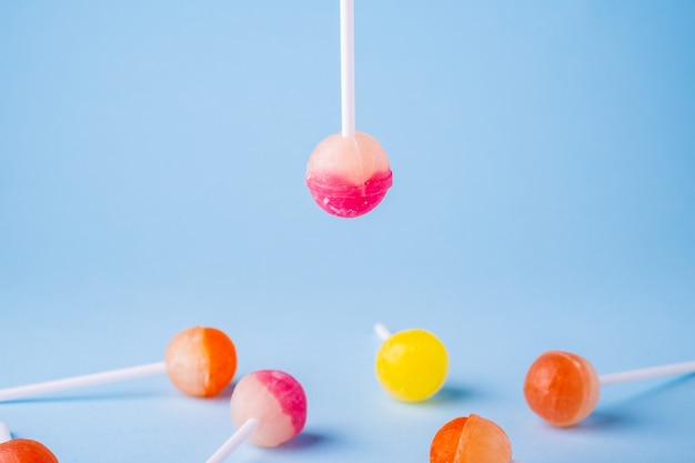 Ondersteboven lolly snoep op blauwe ondergrond boven andere lollies