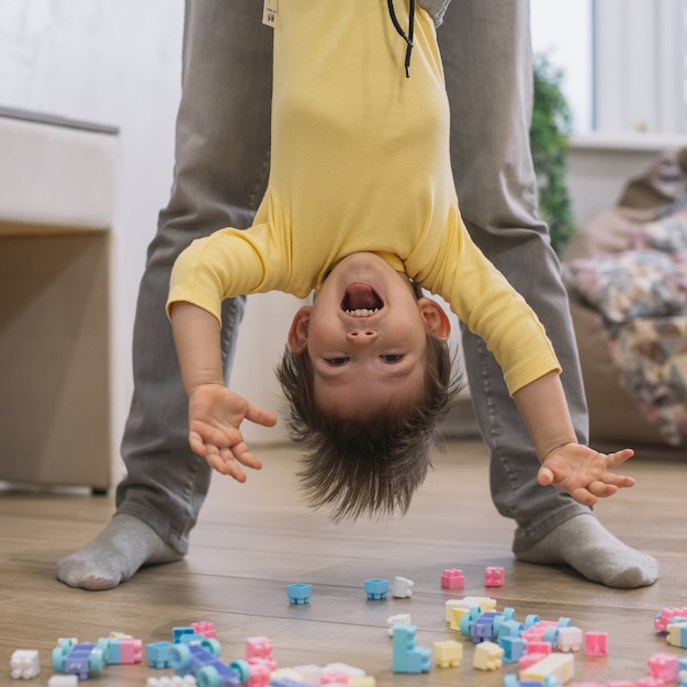 Foto ondersteboven zoon vastgehouden door vader