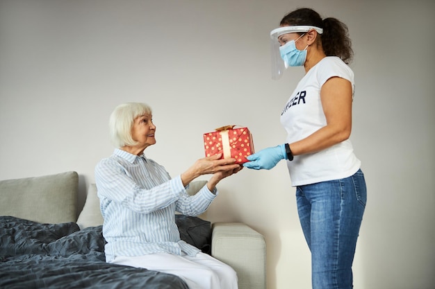 Ondersteuner feliciteert een gepensioneerde met een cadeautje