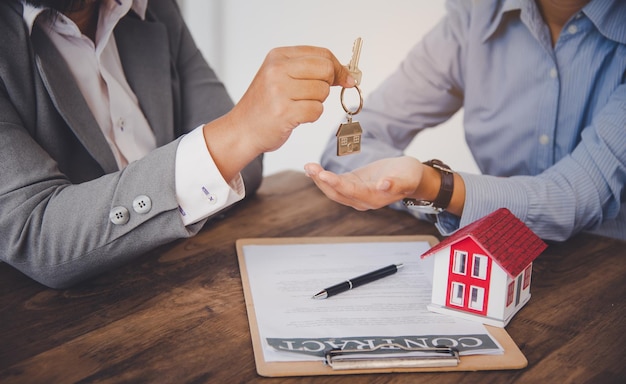 Ondertekenaars van het huis ondertekenen handtekening lening document voor eigenwoningbezit met eigendom van makelaars. Hypotheek en vastgoedbeleggingen, woningverzekeringen