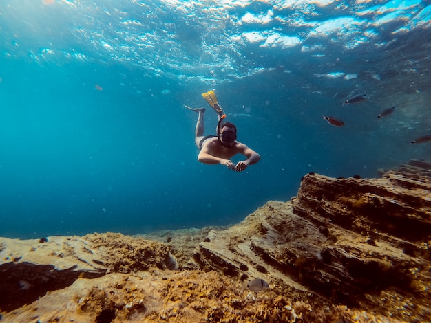 Onderwater foto van mannen duiker die in het zeewater snorkelt