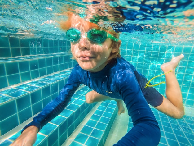 Onderwater jonge jongen plezier in het zwembad met bril Zomervakantie plezier