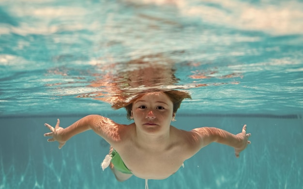 Onderwater kind in het zwembad Schattige jongen jongen zwemmen in het zwembad onder water