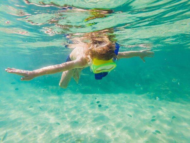 Onderwater natuurstudie jongen snorkelen in helderblauwe zee