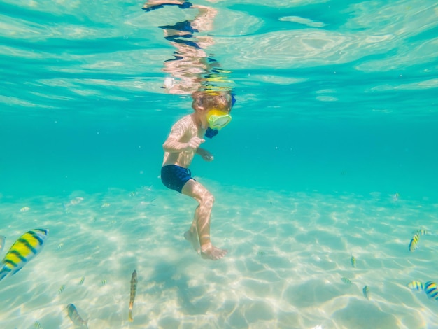 Onderwater natuurstudie jongen snorkelen in helderblauwe zee