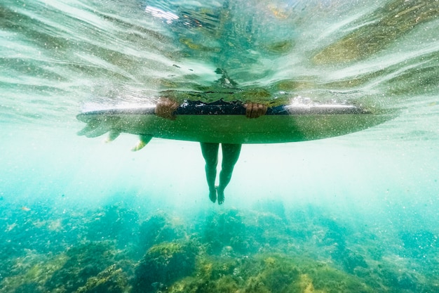 Foto onderwater schot van vrouw met surfplank