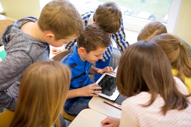 onderwijs, basisschool, leren, technologie en mensen concept - groep schoolkinderen met tablet pc-computer plezier op pauze in de klas