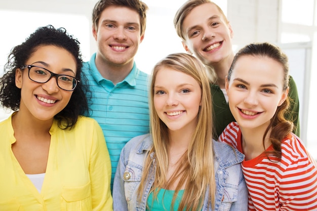 onderwijs en geluk concept - groep jonge lachende mensen thuis of op school