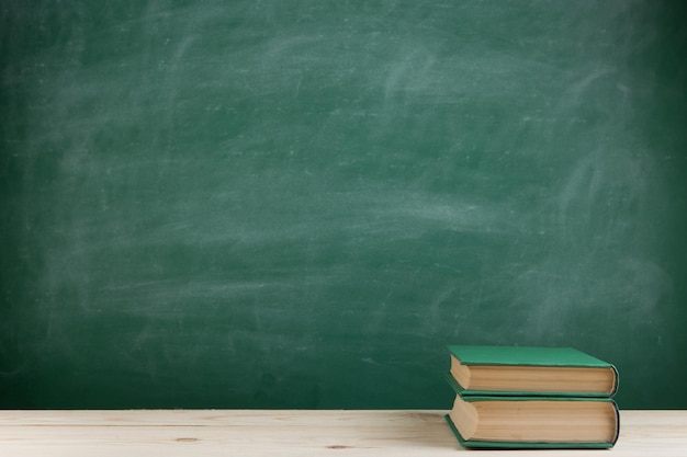 Onderwijs en lezen concept groep kleurrijke boeken op de houten tafel in de klas schoolbord achtergrond