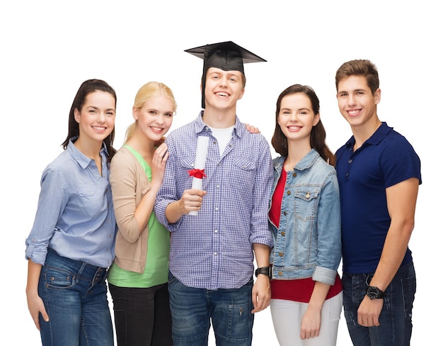 onderwijs en mensenconcept - groep staande glimlachende studenten met diploma en hoekkapje