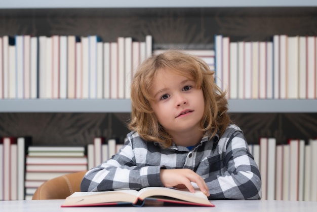 Onderwijs en school concept Kind leest een boek in een schoolbibliotheek Schooljongen onderwijsconcept