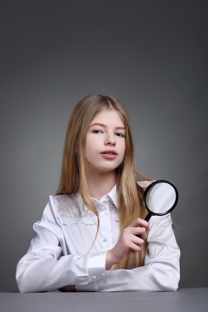 Onderwijs en school concept klein student meisje op zoek met vergrootglas