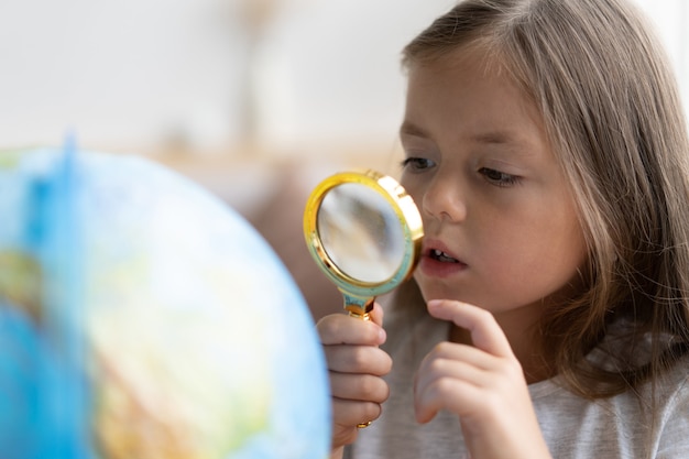 Onderwijs en schoolconcept. kind meisje wijzend op wereldbol.