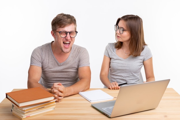 Onderwijs en studentenconcept een grappig paar die oefeningen of huiswerk met laptop doen