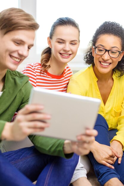 onderwijs en technologie concept - lachende studenten met tablet pc-computer thuis