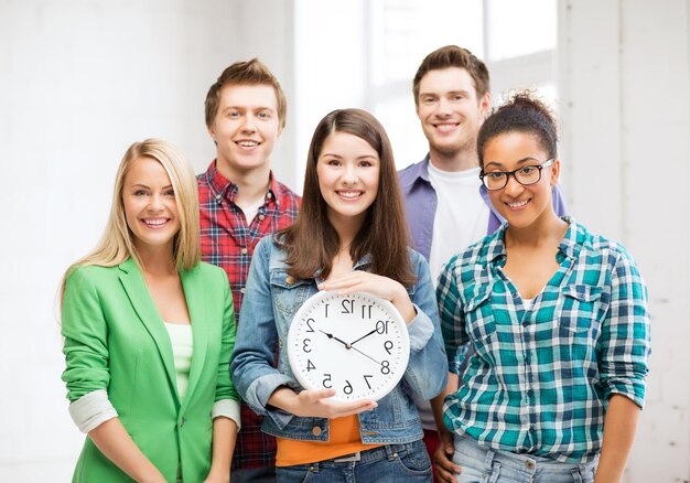 onderwijs en tijdconcept - groep studenten op school met klok