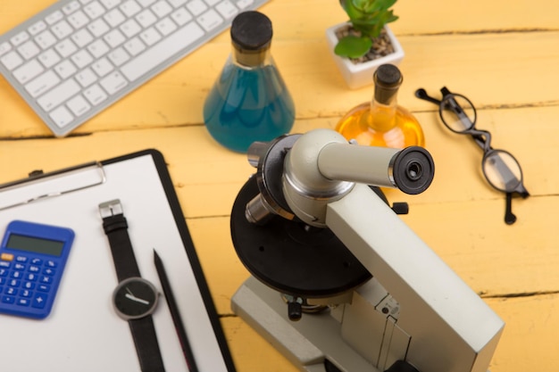 Foto onderwijs en wetenschap concept microscoop boek vergrootglas toetsenbord brillen chemische vloeistoffen