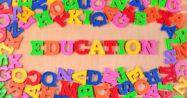 Foto onderwijs geschreven door plastic kleurrijke letters op een houten achtergrond