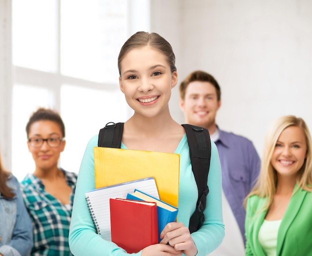 onderwijs, jeugd, school, teamwork concept - lachende student met boeken en schooltas