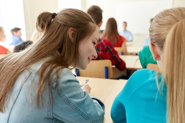 Foto onderwijs, middelbare school, leren en mensenconcept - groep studenten die test schrijven