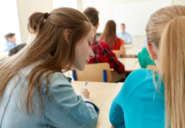 onderwijs, middelbare school, leren en mensenconcept - groep studenten die test schrijven