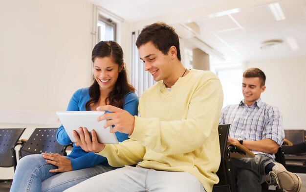 onderwijs, middelbare school, teamwork en mensenconcept - groep lachende studenten met tablet-pc's die foto's of video's maken in de collegezaal