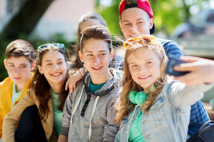 Foto onderwijs, middelbare school, technologie en mensenconcept - groep gelukkige tienerstudenten of vrienden die selfie maken met een smartphone