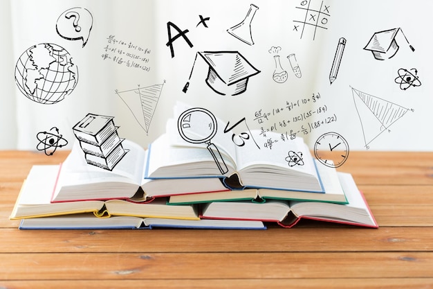 Foto onderwijs, school, literatuur, lezen en kennis concept - close-up van boeken op houten tafel over schoolkrabbels