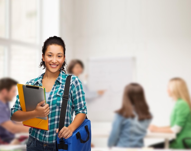 onderwijs, technologie en mensen concept - lachende vrouwelijke Afro-Amerikaanse student met mappen, tas en tablet pc